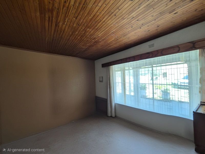 An empty living room featuring a timber tongue and groove ceiling, carpeted flooring, and large windows with security bars.