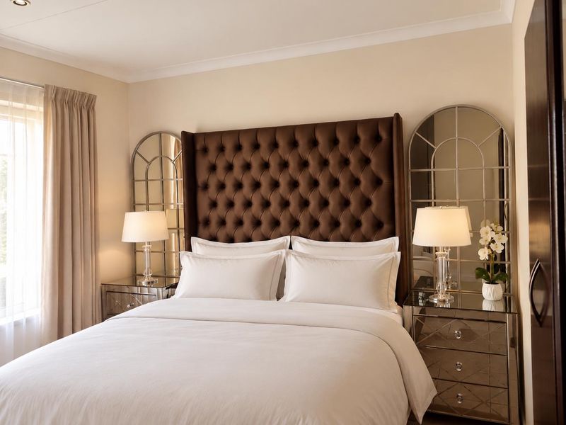 A well-maintained bedroom featuring neutral wall finishes, cove cornicing, and recessed downlighting, creating a bright and comfortable living space.