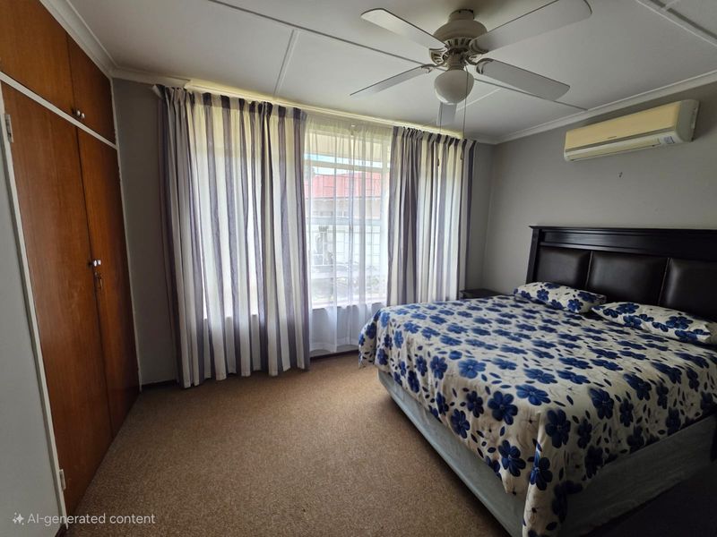A functional bedroom featuring built-in wooden wardrobes, a ceiling fan, and a wall-mounted air conditioning unit, providing comfortable climate control.