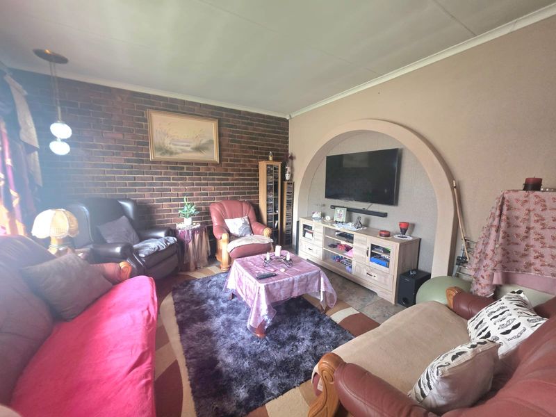 A cozy living room featuring an exposed brick wall and a distinctive arched wall niche, providing a unique architectural focal point.
