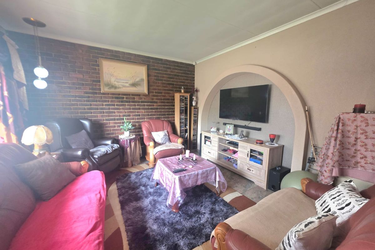 A cozy living room featuring an exposed brick wall and a distinctive arched wall niche, providing a unique architectural focal point.