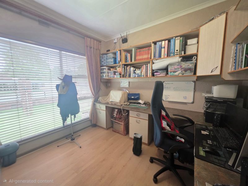A functional home office featuring built-in desk space and extensive wall-mounted shelving, providing ample storage and workspace.
