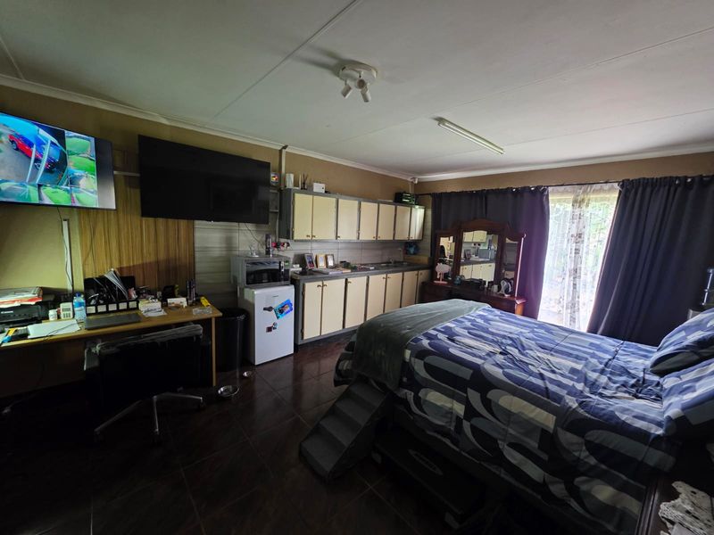 A bedroom featuring built-in cabinetry, tiled flooring, and a sliding glass door providing access to the exterior.
