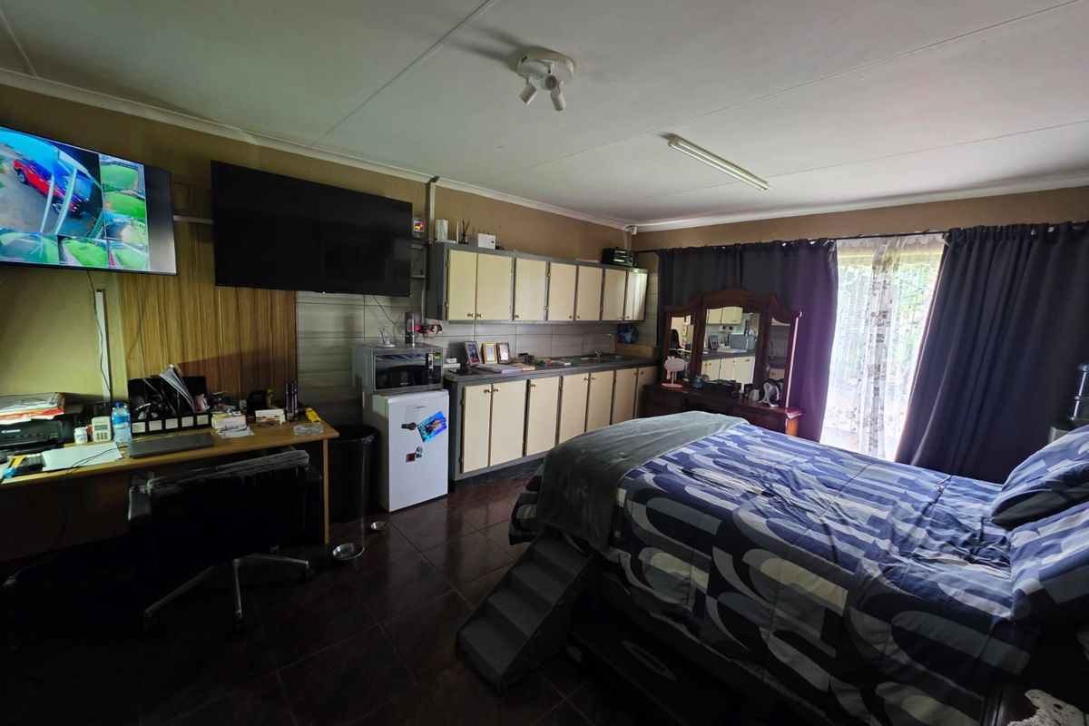 A bedroom featuring built-in cabinetry, tiled flooring, and a sliding glass door providing access to the exterior.