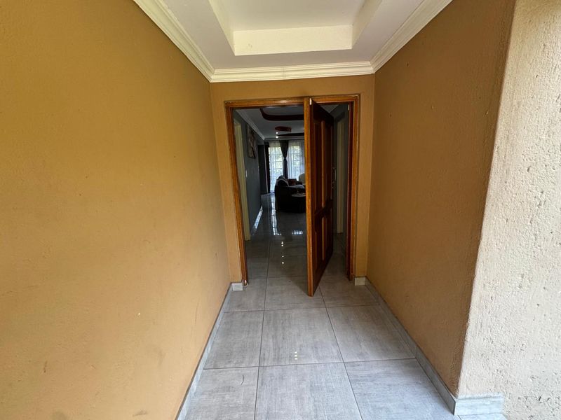 A functional entrance foyer featuring tiled flooring and a coved ceiling, providing a clear transition into the main living area.