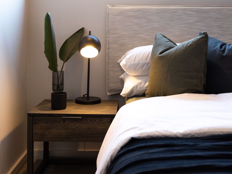 A well-lit bedroom featuring tiled flooring and a modern window, showcasing a clean and contemporary aesthetic.