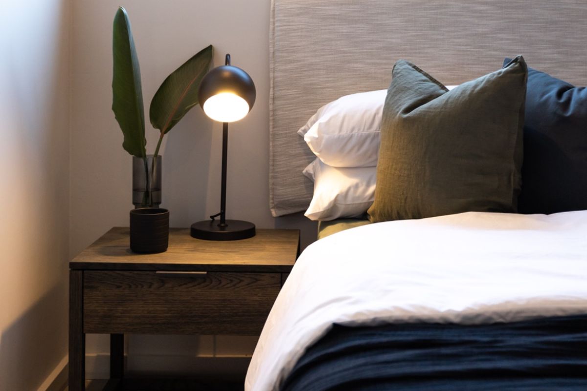 A well-lit bedroom featuring tiled flooring and a modern window, showcasing a clean and contemporary aesthetic.