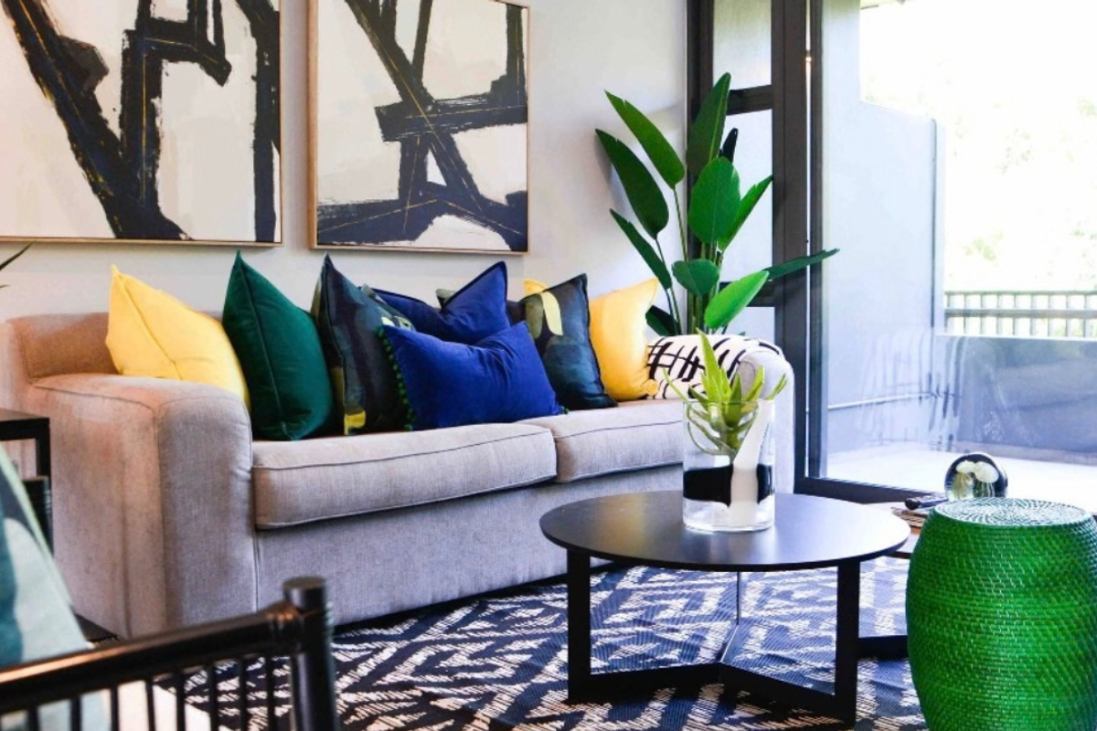 A well-lit living room featuring large sliding glass doors that provide access to an outdoor balcony area.