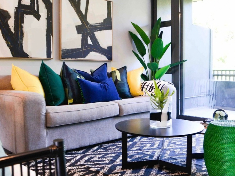 A well-lit living room featuring large sliding glass doors that provide access to an outdoor balcony area.