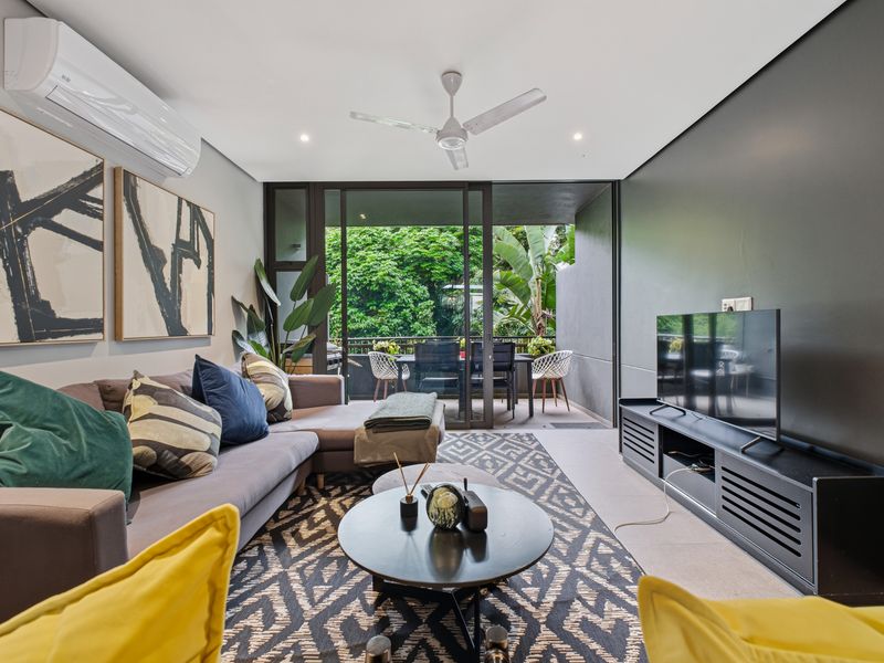 Modern living room featuring tiled flooring, split-system air conditioning, ceiling fan, and large sliding glass doors opening to a private balcony.