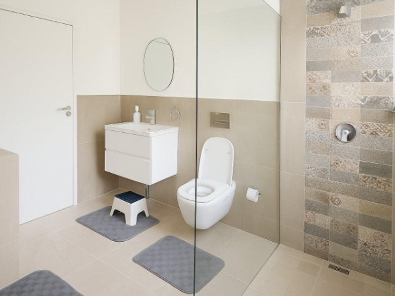 Modern bathroom featuring a wall-hung vanity, wall-mounted toilet with concealed cistern, and a spacious walk-in shower with decorative mosaic tiling.