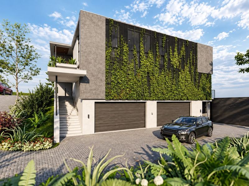 Modern residential exterior featuring a double garage, vertical garden facade, paved driveway, and an elevated balcony entrance.