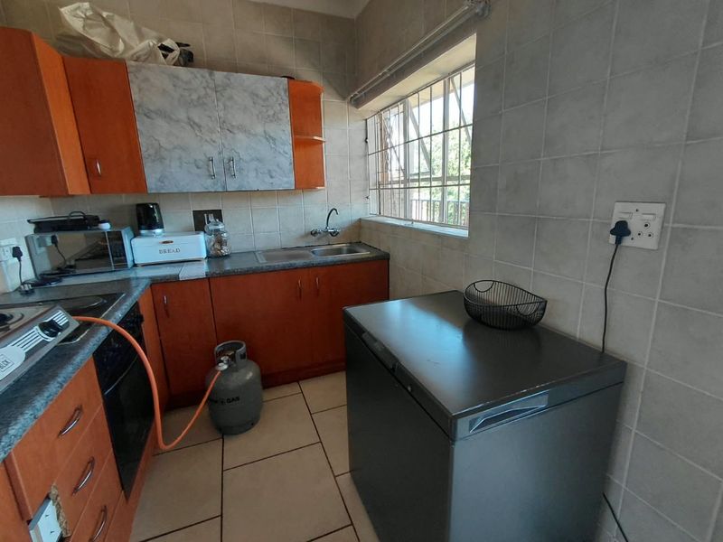 Compact kitchen featuring built-in cabinetry, tiled backsplash, and functional workspace with a gas hob and oven setup.
