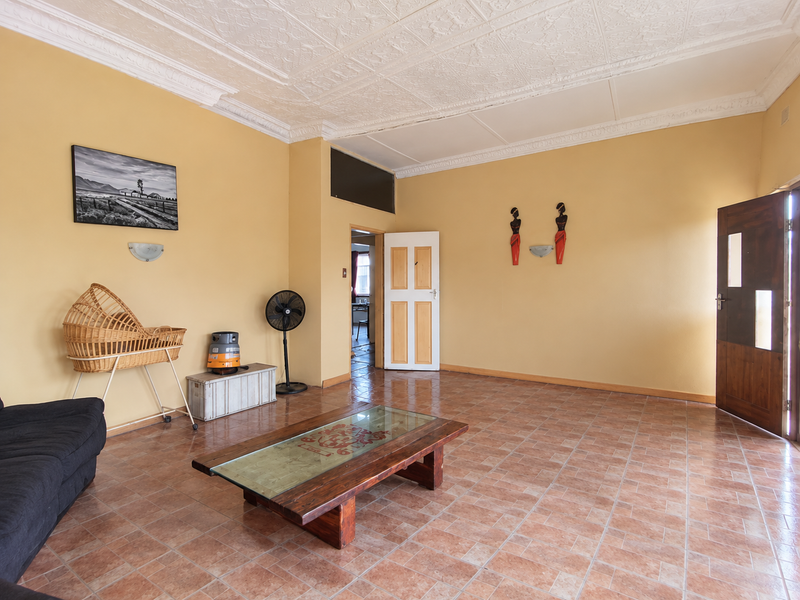 Spacious living room featuring traditional pressed metal ceilings, tiled flooring, and direct access to adjacent rooms.