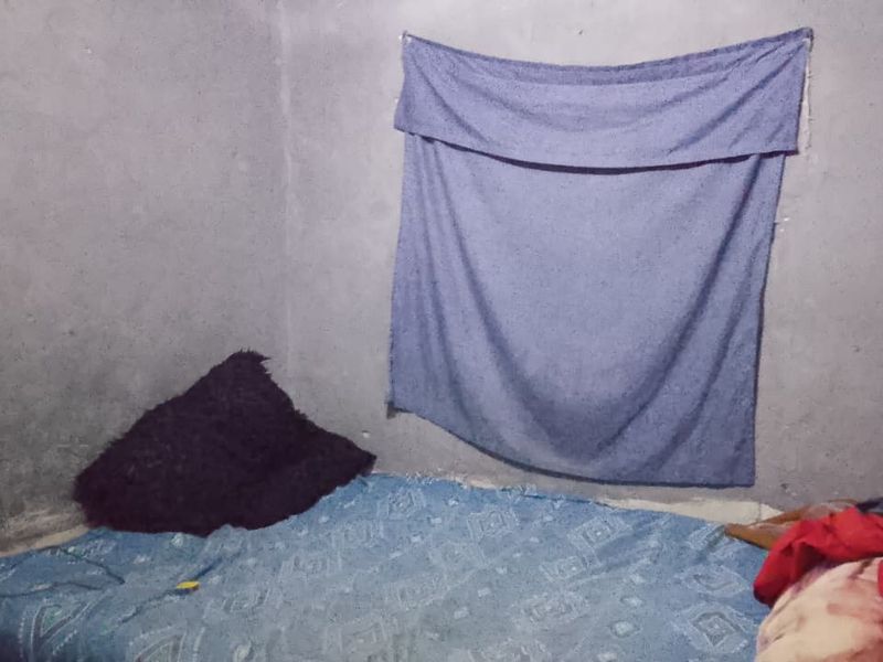 A bedroom featuring unfinished concrete walls, providing a blank canvas for renovation and interior finishing.