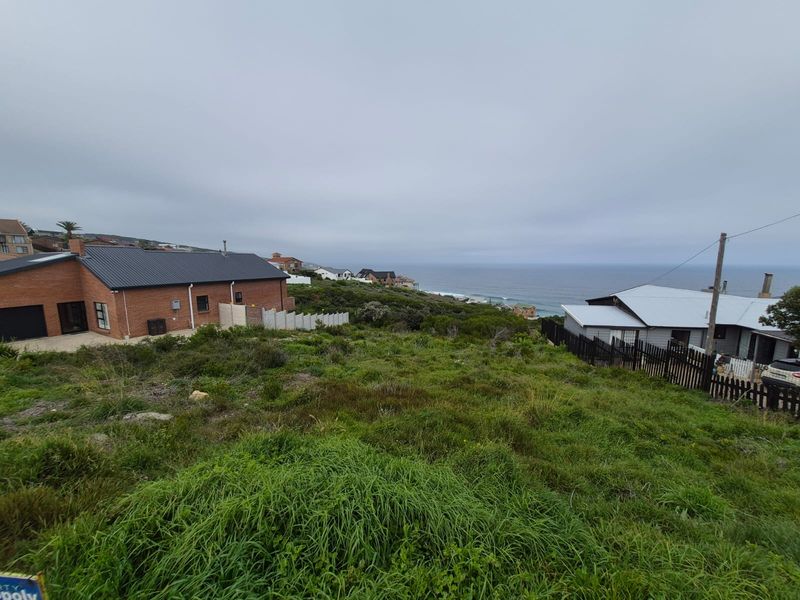 A view of the vacant residential land overlooking the coastline and surrounding neighborhood properties.