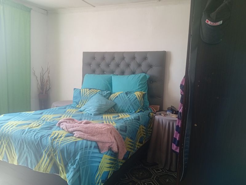 A standard bedroom featuring a tufted headboard and tiled flooring.