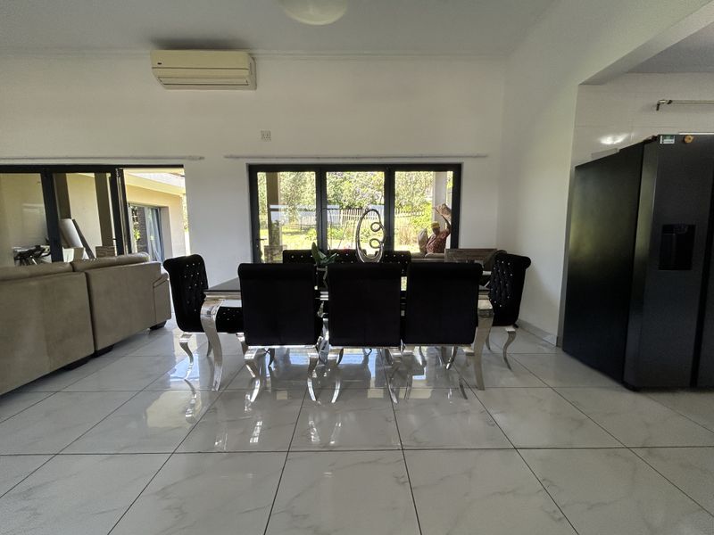 Spacious open-plan living and dining area featuring large sliding glass doors that provide ample natural light and direct access to the outdoor patio.