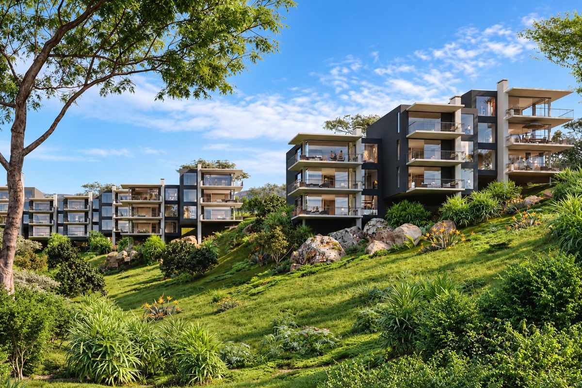 A modern apartment complex featuring tiered balconies and expansive glass facades, set against a beautifully landscaped hillside.