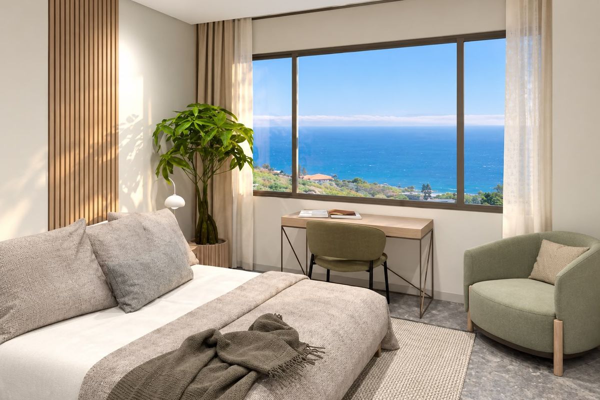 A modern, well-appointed bedroom featuring elegant timber slat wall detailing and a large window offering expansive ocean views.