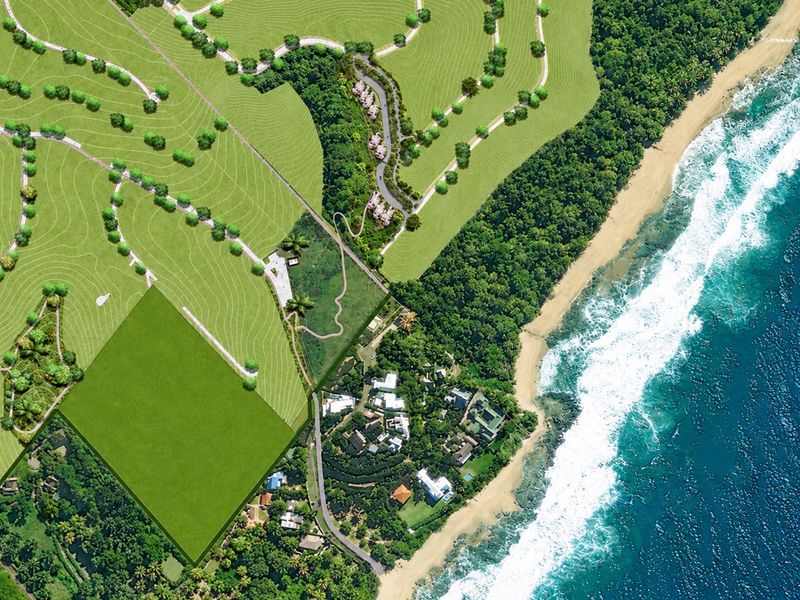 An aerial view of the coastal property development, showcasing the beach frontage, surrounding lush landscape, and site layout.