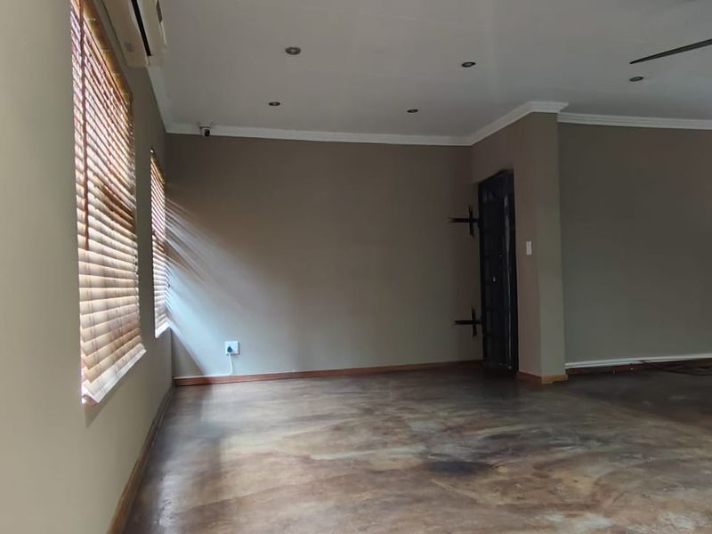 Spacious, empty living area featuring polished concrete floors, recessed lighting, a ceiling fan, and an integrated air conditioning unit.