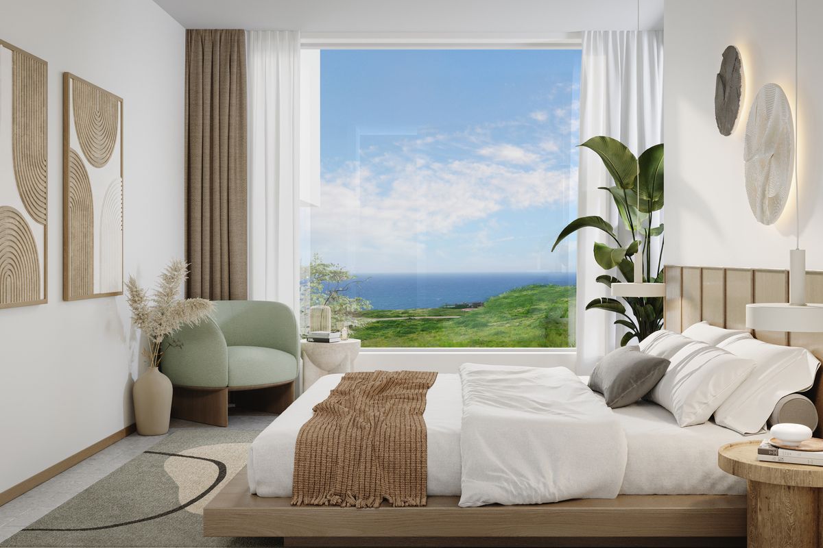 A modern, well-appointed bedroom featuring a large picture window with expansive ocean and coastal views, clean lines, and contemporary wall lighting.