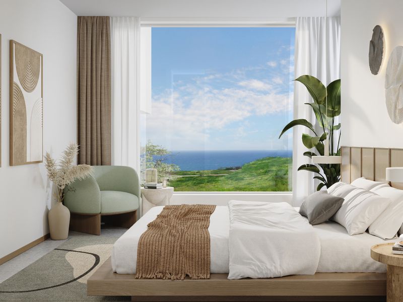 A modern, well-appointed bedroom featuring a large picture window with expansive ocean and coastal views, clean lines, and contemporary wall lighting.