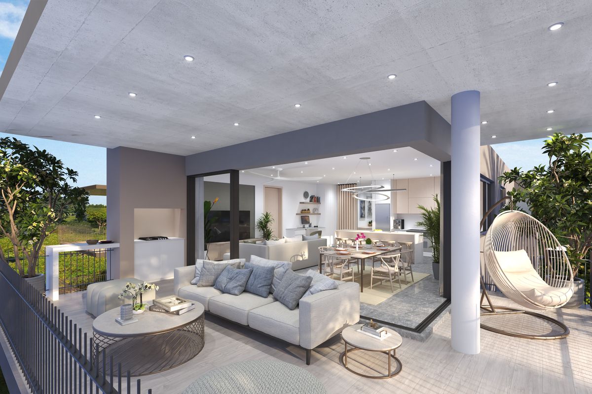 A modern open-plan apartment layout featuring a seamless transition between the indoor living area and a spacious covered balcony with a built-in braai.