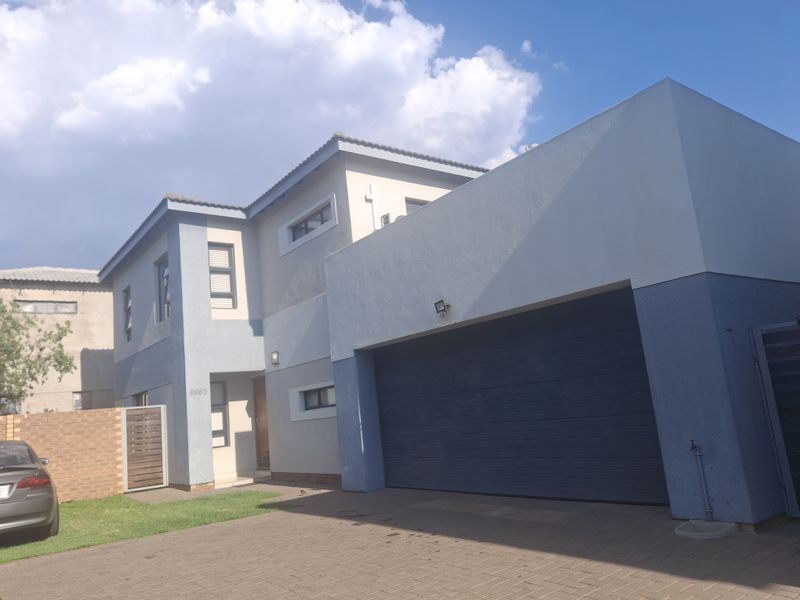 Modern double-storey residential property featuring a paved driveway, integrated double garage, and contemporary exterior facade with neutral paint finishes.