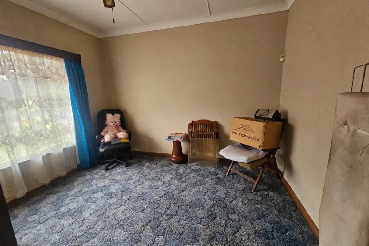 A bedroom featuring a coved ceiling, ceiling fan, and carpeted flooring, offering a blank canvas for potential updates and interior design improvements.