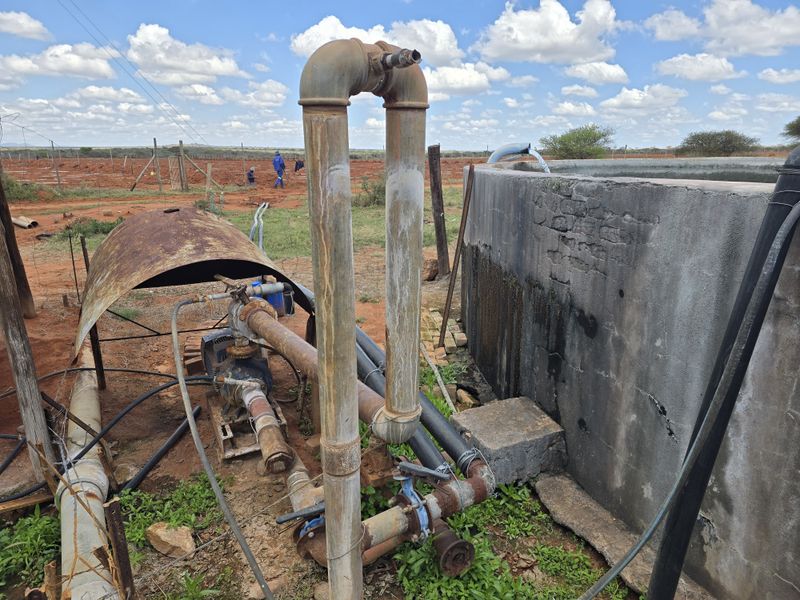 Agricultural water pump and concrete reservoir infrastructure located on the farm property, showing signs of age and weathering.