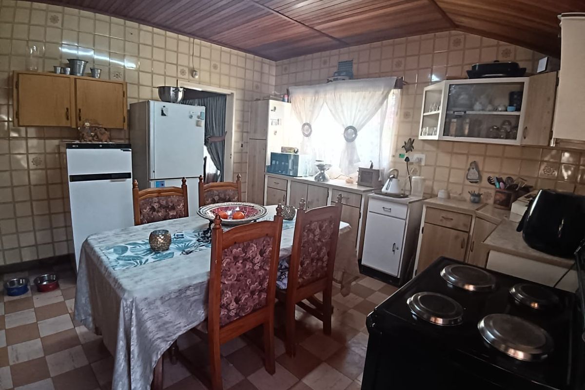 A dated kitchen featuring tiled walls, timber ceiling, and built-in cabinetry, offering potential for a modern renovation to update the space.