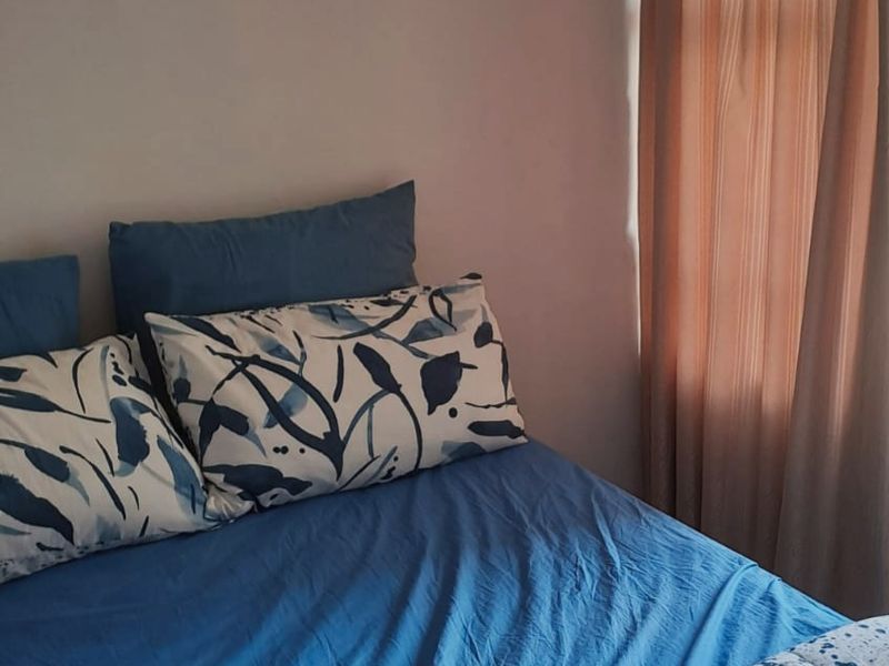 A bedroom interior featuring a window with installed curtain rails.
