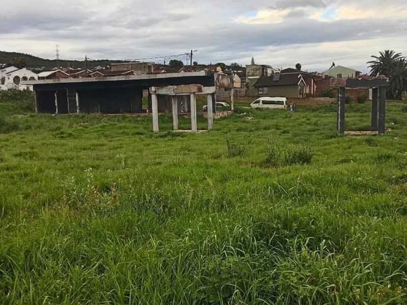 Vacant residential land featuring an incomplete concrete structure and foundation, situated in an established neighborhood setting.