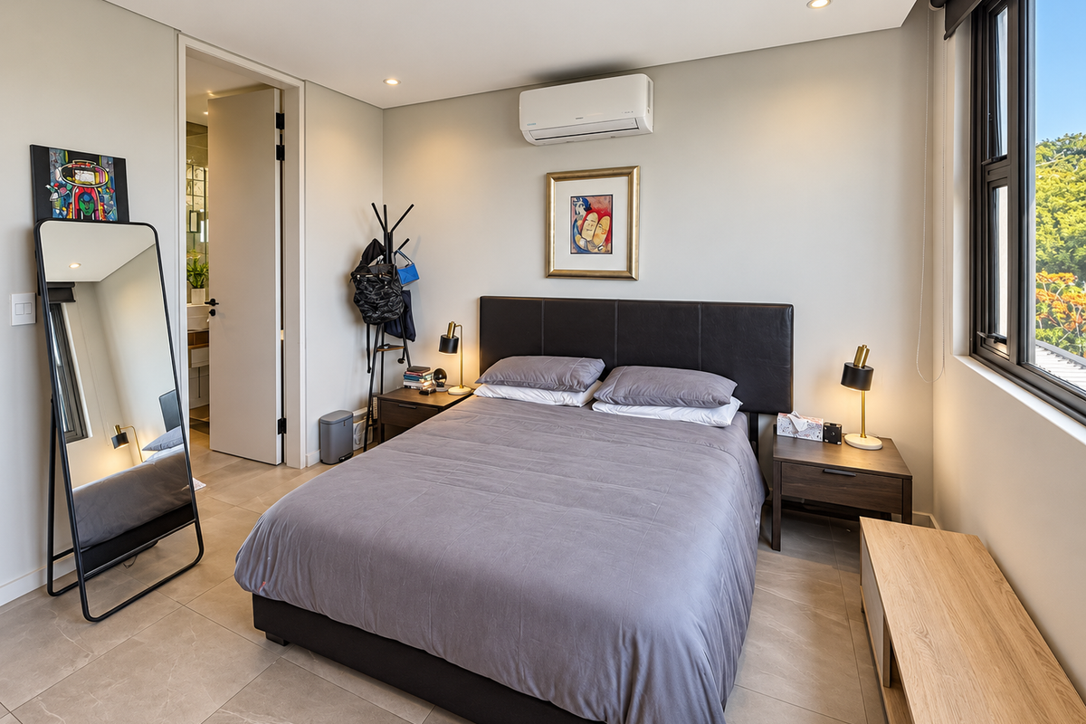 A well-maintained bedroom featuring modern tiled flooring, a split-system air conditioner, and large windows allowing for natural light.