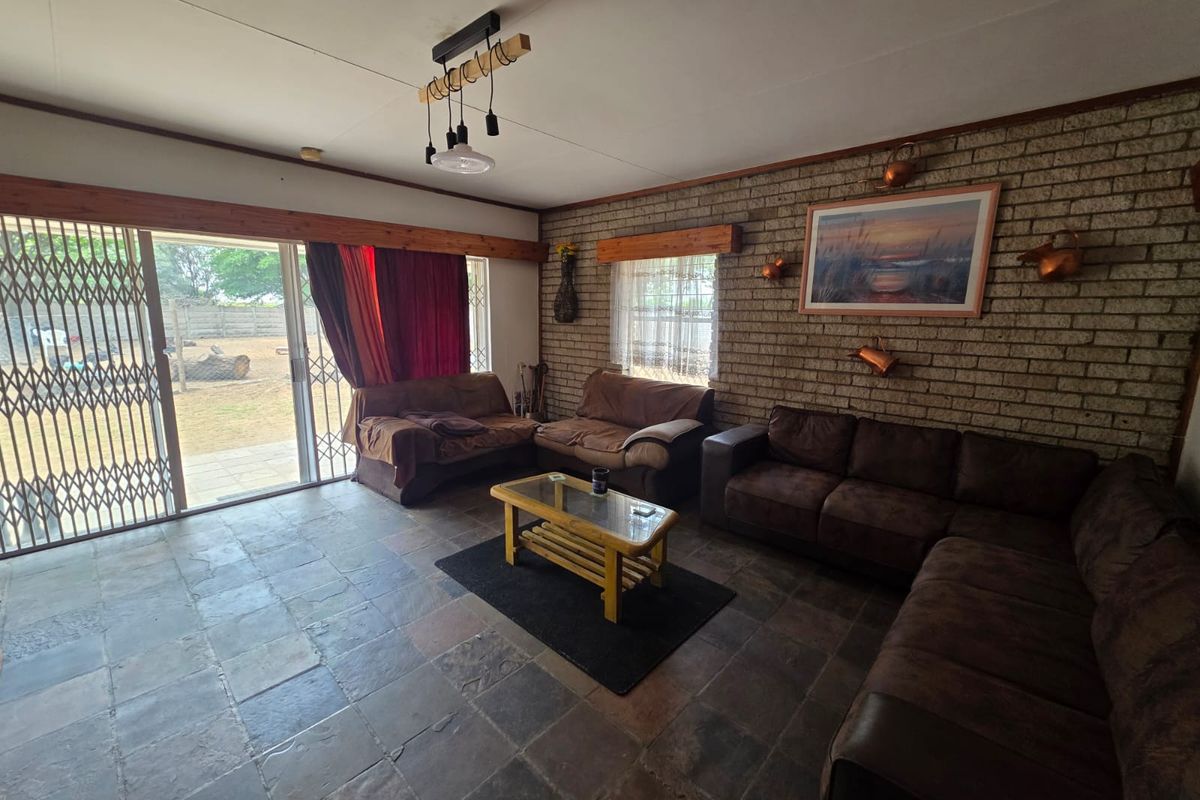 Spacious living room featuring exposed brick walls, slate tile flooring, and large sliding glass doors providing access to the outdoor area.