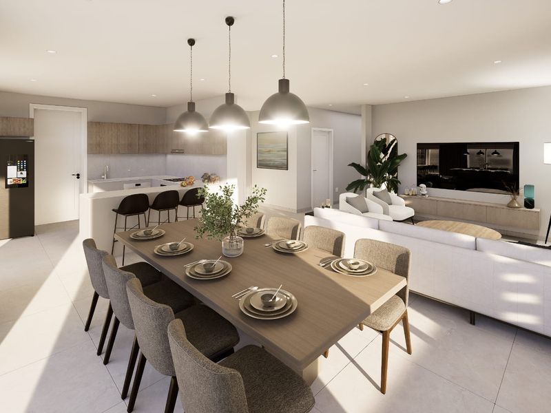 Modern open-plan living area featuring a contemporary kitchen with island, dining space, and tiled flooring, creating a seamless and functional layout.