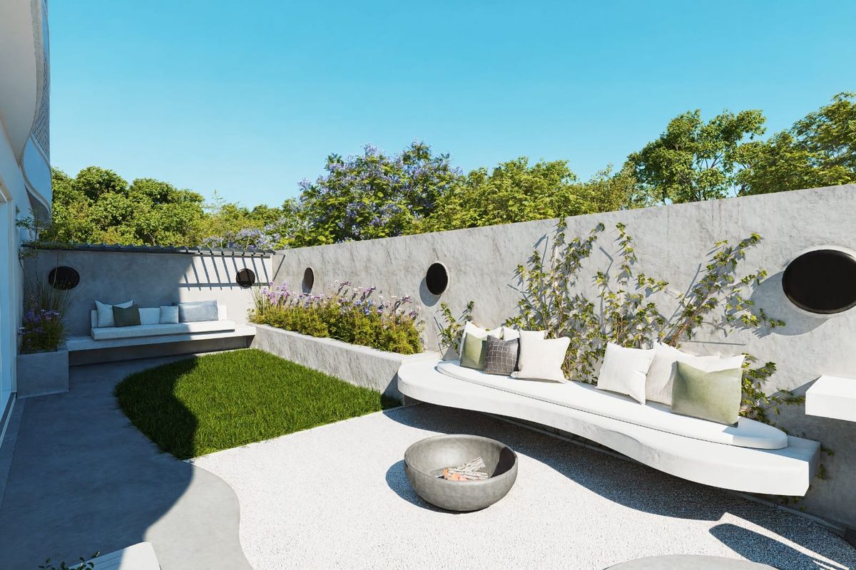 A modern outdoor patio area featuring built-in concrete bench seating, a raised planter box, and a gravel courtyard with a central fire pit.