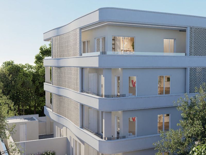 Modern apartment building exterior featuring curved architectural lines, glass balustrades, and decorative brickwork detailing.