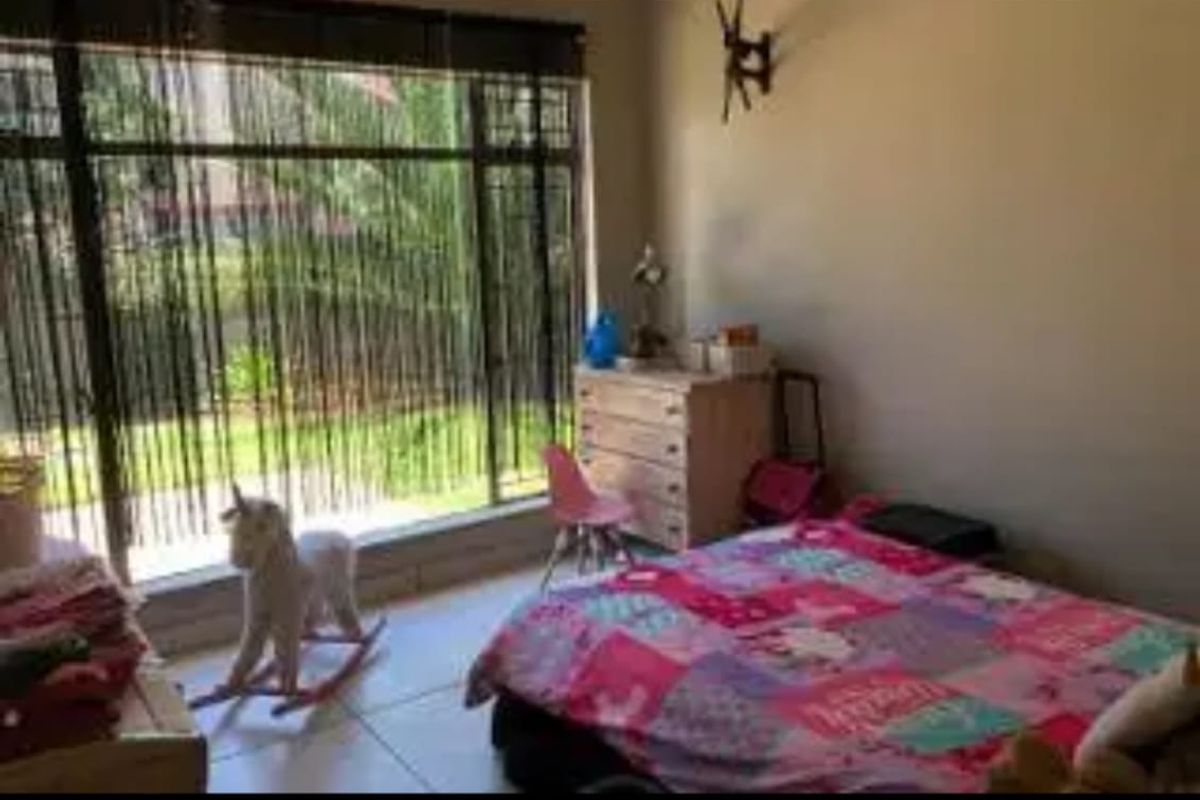 A bedroom featuring large windows that provide natural light and tiled flooring throughout.