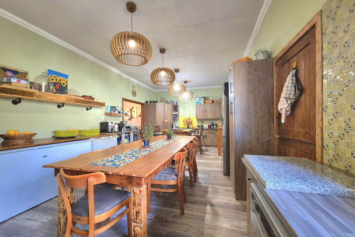 Spacious kitchen featuring wood-toned cabinetry, a mosaic tile backsplash, and modern pendant lighting, offering a functional layout with ample preparation space.