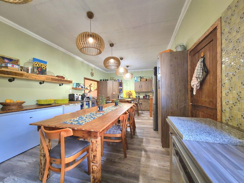Spacious kitchen featuring wood-toned cabinetry, a mosaic tile backsplash, and modern pendant lighting, offering a functional layout with ample preparation space.