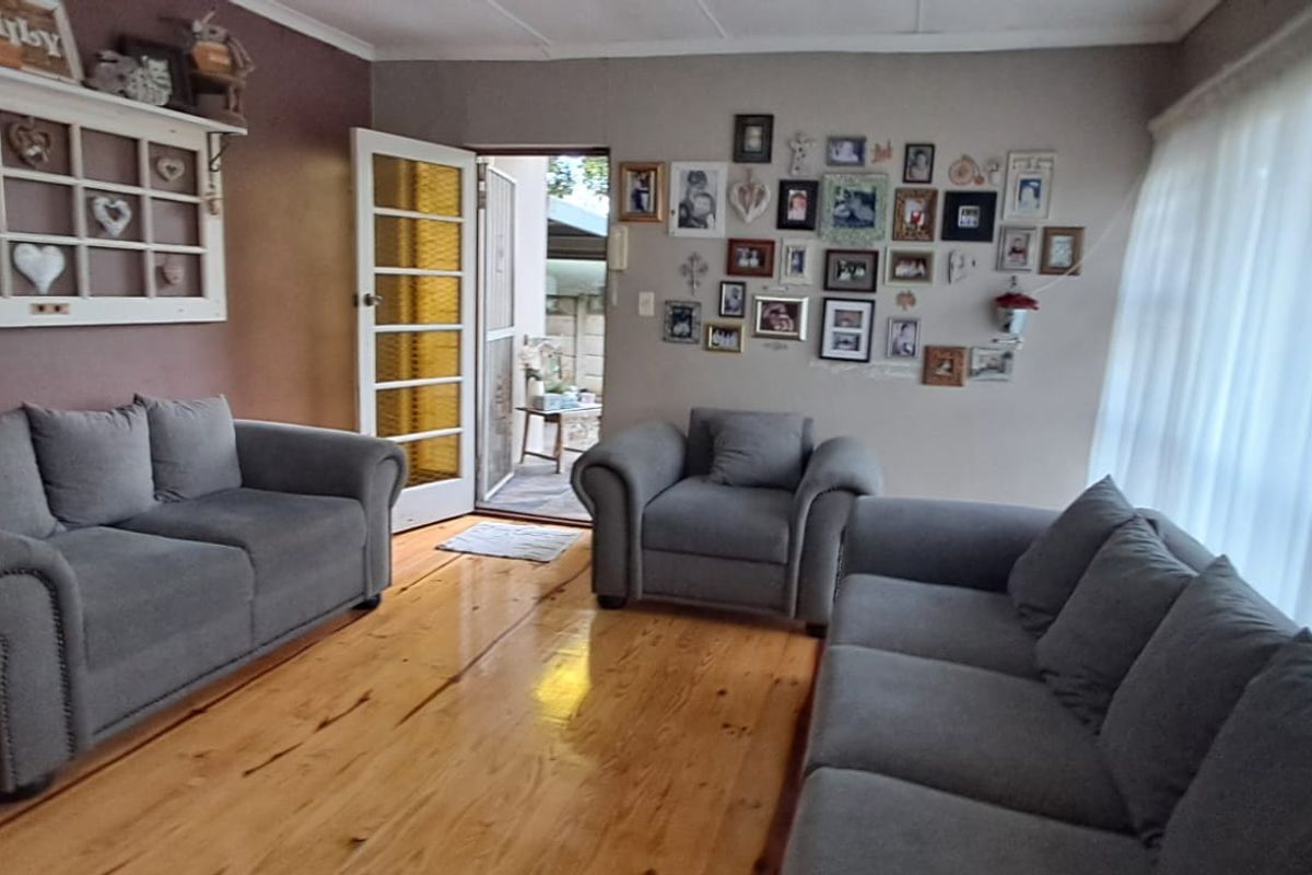 A comfortable living room featuring polished timber flooring and a classic french door providing access to the outdoor area.