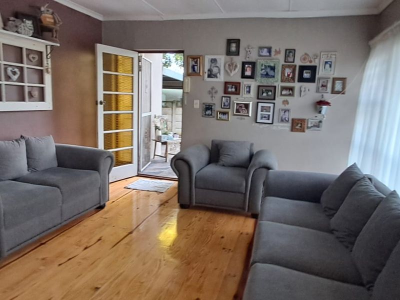 A comfortable living room featuring polished timber flooring and a classic french door providing access to the outdoor area.