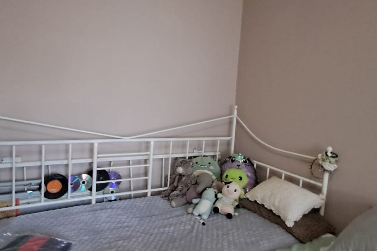 A bedroom featuring neutral wall paint and a metal bed frame.