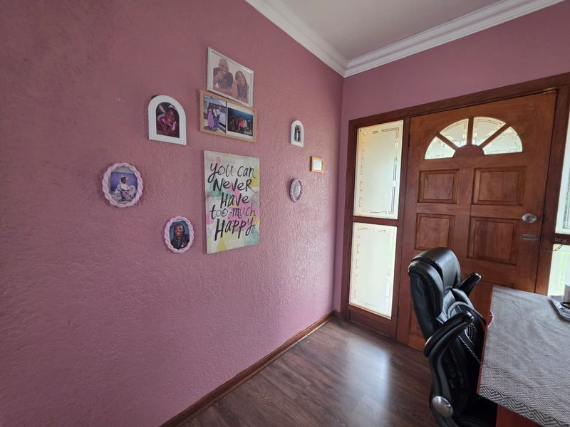 Entrance area featuring a solid timber front door with decorative glass sidelights and laminate flooring.