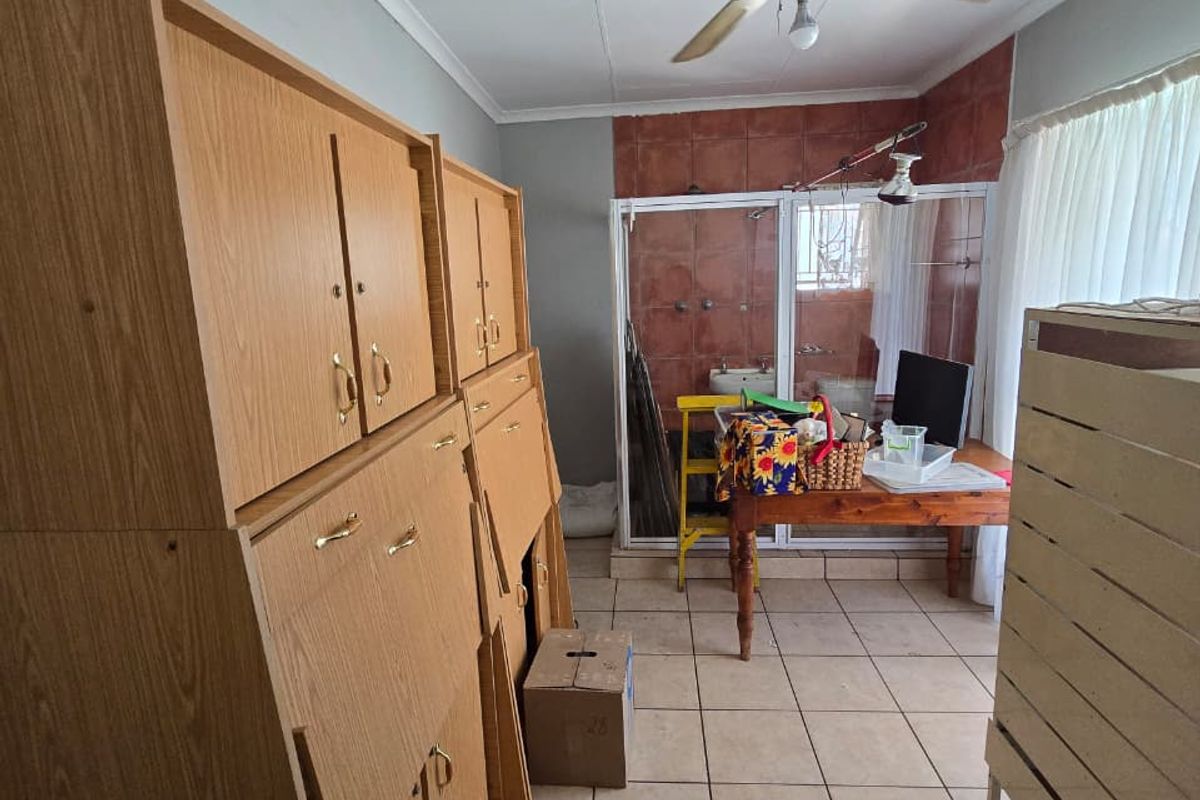 Bedroom featuring tiled flooring, a ceiling fan, built-in cupboards, and an integrated en-suite shower area.