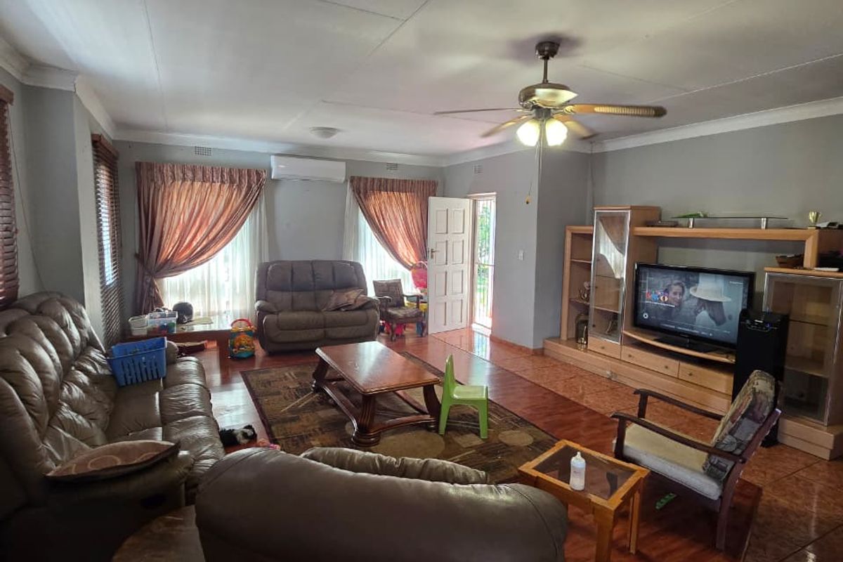 Spacious living room featuring tiled flooring, a ceiling fan, split-system air conditioning, and a built-in entertainment unit.