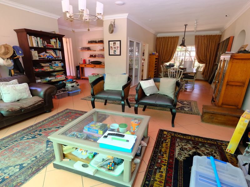 Spacious open-plan living and dining area featuring tiled flooring and coved cornicing, offering a versatile layout for family living.